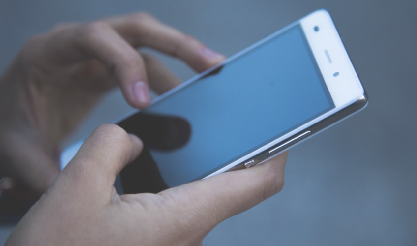 A person using a smartphone held in both hands