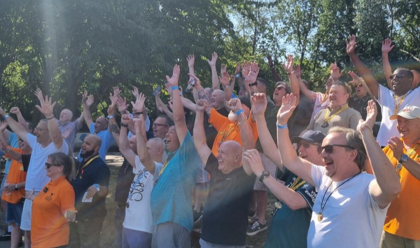 London Taxi Drivers’ Charity for Children supporters gathered outdoors with their hands raised